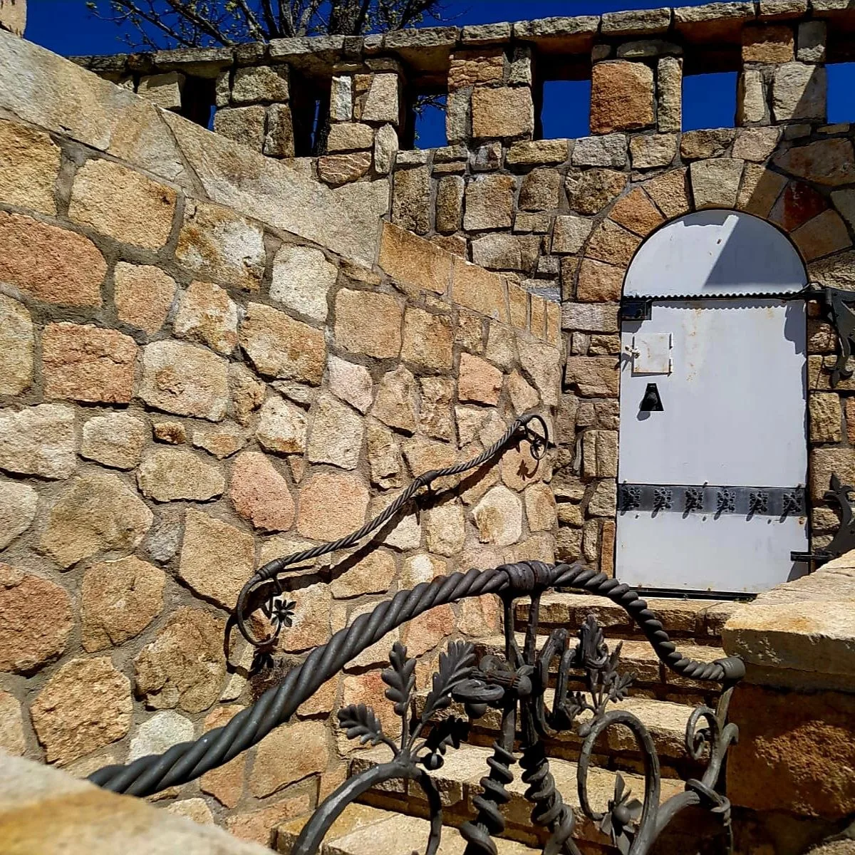 Detalle del muro de piedra y la forja