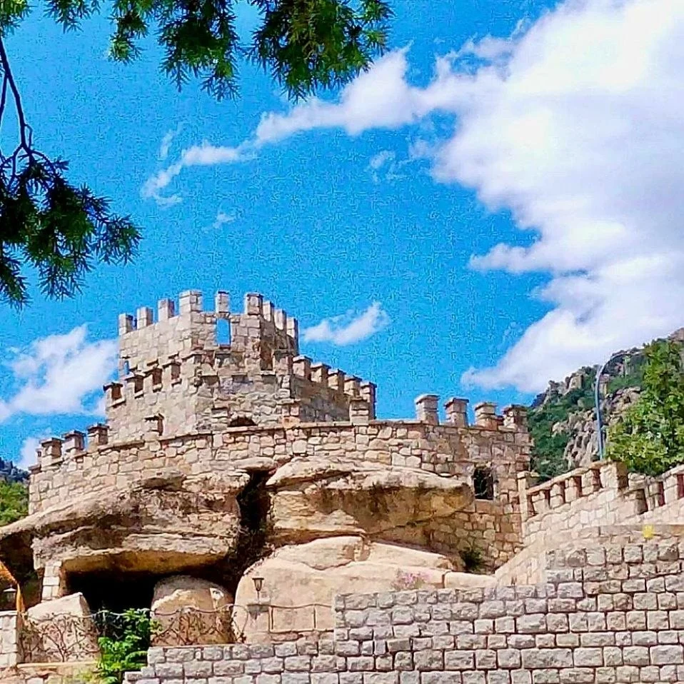 Torre del castillo de la Finca El Castillo vista entre árboles, en La Cabrera, Madrid